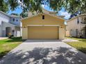 A large garage door is the focal point, flanked by exterior lights and an ample driveway at 4633 White Bay Cir, Wesley Chapel, FL 33545
