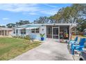 Inviting home exterior features a screened-in porch and adjacent patio seating, perfect for outdoor enjoyment at 4707 Alma St, New Port Richey, FL 34652