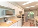Well-lit kitchen with stainless steel appliances, white cabinets, and a view to the outside at 4997 Bostonian Loop, New Port Richey, FL 34655