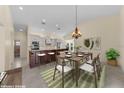 Open-concept kitchen and dining area featuring a large island, modern appliances, and stylish chandelier at 5290 White Sand Ne Cir, St Petersburg, FL 33703