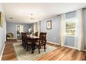 Formal dining room with wood floors, stylish lighting fixture, a decorative rug and bright windows at 626 Marphil Loop, Brandon, FL 33511