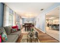 Living room featuring wood flooring, a neutral sofa, bright decor and an open access to the kitchen at 626 Marphil Loop, Brandon, FL 33511