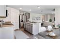 Open-concept kitchen with stainless steel appliances, center island, and seamless flow into the living area at 6955 Broad River Ave, Land O Lakes, FL 34638