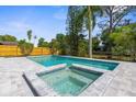 Beautiful backyard pool with connecting spa, surrounded by a well-maintained patio and mature landscaping at 7050 Jenner Ave, New Port Richey, FL 34655