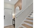 Hallway featuring staircase, decorative mirror, hall table and neutral paint scheme at 7413 French Marigold Ave, Tampa, FL 33619