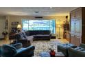 Bright living room with view of pool from a large window, comfortable seating, and stylish decor at 836 Magellan Dr, Sarasota, FL 34243