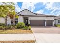 Charming single-story home with a tile roof, brick driveway, and well-manicured landscaping at 10982 Banyan Breeze Blvd, Land O Lakes, FL 34638
