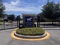 Paddock Manor community entrance featuring a manicured circular median and an iron gate at 11219 Paddock Manor Ave, Riverview, FL 33569