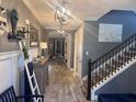 Inviting foyer with wood-look tile flooring, decorative ladder, and staircase with dark wood railing at 11219 Paddock Manor Ave, Riverview, FL 33569