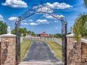 Elegant gated entrance with stone pillars and a long driveway leading to the residence at 11715 Taylor Rd, Thonotosassa, FL 33592