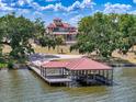 Picturesque waterfront property featuring a private dock and boat lift with a red tile roof at 11715 Taylor Rd, Thonotosassa, FL 33592
