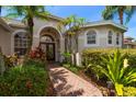 Home entrance with arched doorway, double doors, paver walkway, and vibrant landscaping at 11910 Keating Dr, Tampa, FL 33626