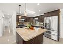 Modern kitchen features a center island, granite countertops, stainless steel appliances, and ample cabinet space at 14917 Philmore Rd, Tampa, FL 33613