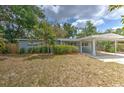 Charming one-story home featuring a covered carport and a well-maintained front yard with mature trees at 1511 Meridel Ave, Tampa, FL 33612