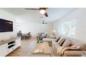 Cozy living room with a ceiling fan, light wood floors, and large windows for natural light at 1849 Del Robles Dr, Clearwater, FL 33764
