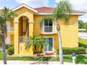 Two-story yellow condominium building with a red tile roof and lush landscaping at 21012 Picasso Ct # 201, Land O Lakes, FL 34637