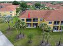Aerial view of condominium showcasing balcony, lush landscaping, and proximity to palm trees at 21012 Picasso Ct # 201, Land O Lakes, FL 34637