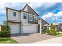 Two-story home with a brick-paved driveway leading to a two-car garage and featuring an attractive, modern design at 21590 Violet Periwinkle Dr, Land O Lakes, FL 34637