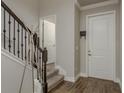Inviting foyer with wood-look tile flooring, a staircase, and a coat rack enhancing the home's entrance appeal at 21590 Violet Periwinkle Dr, Land O Lakes, FL 34637