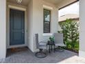 Inviting front porch with seating, a stylish door, and charming details creating a welcoming entrance to the home at 21590 Violet Periwinkle Dr, Land O Lakes, FL 34637