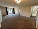 Expansive living room with plush carpeting, access to the screened-in lanai, and neutral wall colors at 229 Mary Dr # 229, Oldsmar, FL 34677