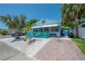 Quaint beach house boasts a brick path, xeriscaping and cheerful turquoise porch, creating a welcoming curb appeal at 2613 Upton S St, Gulfport, FL 33711