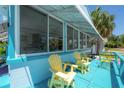 Inviting turquoise porch with comfortable seating, offering a relaxing outdoor space with view through large screened windows at 2613 Upton S St, Gulfport, FL 33711