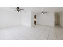 Bright living room featuring ceramic tile flooring, ceiling fans and a glimpse into kitchen at 3213 W Ivy St, Tampa, FL 33607