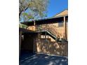 Condo exterior features a wood facade, stairs leading to the front door, and a carport with a covered parking spot at 404 Lennox W Rd # 404, Palm Harbor, FL 34683