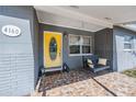 Inviting front porch with a yellow door, a charming porch swing and decorative tile flooring at 4160 30Th N St, St Petersburg, FL 33714