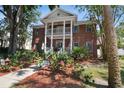 Charming brick facade with a welcoming porch, manicured landscaping, and mature trees at 4309 W Robin Ln, Tampa, FL 33609