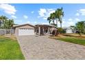 Charming home featuring a two-car garage, manicured lawn, and long, updated brick paver driveway at 4531 44Th S St, St Petersburg, FL 33711