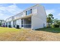 Back exterior of townhome with a screened in patio and well-kept lawn at 5084 Misty Canal Pl, Bradenton, FL 34203