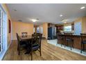 Open-concept dining area adjacent to the kitchen with wood floors and a view into kitchen at 6216 Evansbrook Dr, Zephyrhills, FL 33541