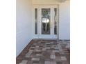 Elegant front door with decorative glass panels and brick-paved entryway, inviting you inside at 6321 Balboa Ln, Apollo Beach, FL 33572