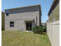 View of the backyard featuring a sliding glass door and a light-colored fence at 6707 Blue Moon Way, Sun City Center, FL 33573