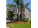 Two-story home with a neutral color scheme, complemented by mature palm trees and green lawn at 6707 Blue Moon Way, Sun City Center, FL 33573