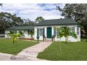 Inviting home with a green door and shutters, a brick walkway, and well-manicured lawn and landscaping at 701 38Th N Ave, St Petersburg, FL 33704
