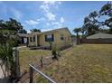 Side view of a charming home with a well-maintained lawn and a chain-link fence at 718 Paris S Ave, St Petersburg, FL 33701