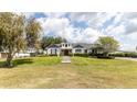 Lovely home with manicured lawn, dormer windows, and stone path, set on a spacious lot with mature trees at 812 Jameson Rd, Lithia, FL 33547