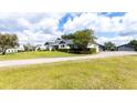 Expansive property featuring a charming white house, covered parking, and large green lawn at 812 Jameson Rd, Lithia, FL 33547
