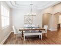Formal dining area with tray ceiling, decorative chandelier, and an adjacent sitting room at 8338 Old Town Dr, Tampa, FL 33647