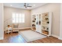 Bright living room with hardwood floors, ceiling fan, built-in shelving, and large windows at 8338 Old Town Dr, Tampa, FL 33647