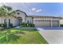 Beautiful home with a well-maintained lawn, mature palm trees, and a spacious three-car garage at 8717 Emeraldwood Way, Land O Lakes, FL 34637