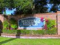 Westlake Village entrance sign with lush landscaping, community information, and brick surround at 915 Rolling Hills Dr, Palm Harbor, FL 34683