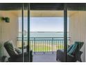 Private balcony with seating offering stunning views of the waterway and lush landscape beyond at 1 Key Capri # 303E, Treasure Island, FL 33706
