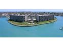Beautiful exterior view of the condominium complex featuring lush landscaping, waterfront views and community pool at 1 Key Capri # 303E, Treasure Island, FL 33706