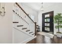 Elegant foyer featuring a modern light fixture, dark hardwood floors, and a black-framed glass door at 101 Biscayne Ave, Tampa, FL 33606