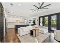 Open-concept living room with a modern kitchen, white sectional sofa, and access to a balcony at 101 Biscayne Ave, Tampa, FL 33606