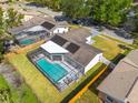 Aerial view of a home with a screened-in pool and solar panels on the roof in a residential neighborhood at 104 Meadowcross Dr, Safety Harbor, FL 34695